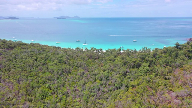 航拍绿松石海岸上的船只由森林对天空，无人机飞向地平线在阳光明媚的一天-怀特黑文海滩，澳大利亚视频素材