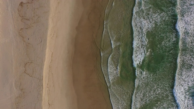 海浪拍打海岸的鸟瞰图由岩石形成，无人机向前飞过海滩-芬格尔头灯，澳大利亚视频素材