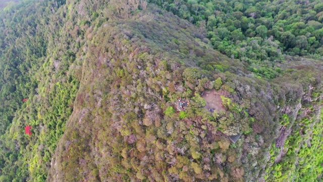 空中倾斜下来拍摄的人在警告山云，无人机向前飞行在自然绿色景观视频素材