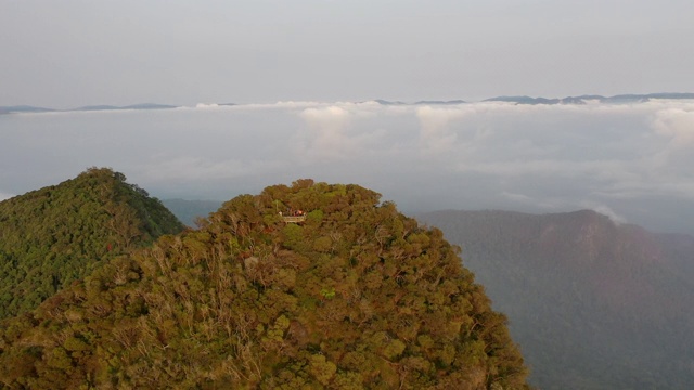 空中平移拍摄云中警戒峰上的人们，无人机在天空中飞过著名的地标视频素材