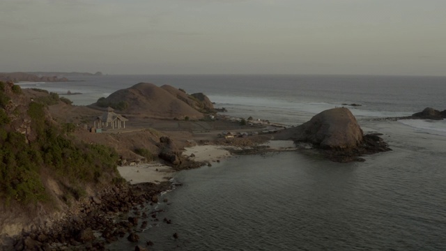 空中平移拍摄的露台上的岩石在海滩上的天空，无人机飞越海上-龙目岛，印度尼西亚视频素材