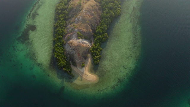 空中拍摄的树木在蓝色的海面上的岛屿在晴朗的一天，无人机飞越海岸线-科莫多岛，印度尼西亚视频素材