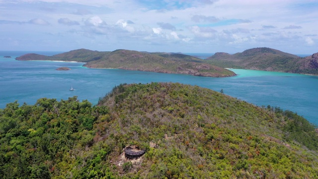 空中拍摄的岛屿在海上对多云的天空晴朗的一天，无人机向前飞行在绿色植物的蓝色海洋-怀特黑文海滩，澳大利亚视频素材