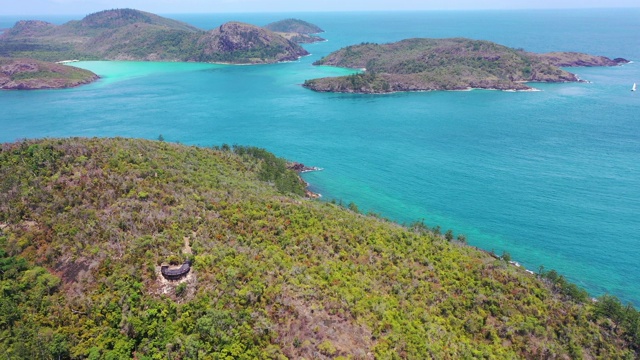 在阳光明媚的日子里，无人机在蓝色海洋的绿色植物上空拍摄岛屿-怀特黑文海滩，澳大利亚视频素材