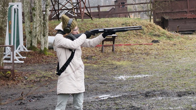 女孩在射击场用猎枪射击目标。弹壳12口径视频下载