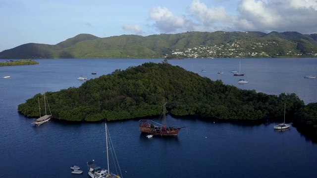 4K镜头鸟瞰马提尼克滨海湾与老海盗船在清澈的蓝色水视频素材