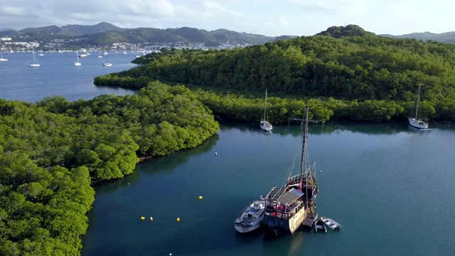 4K镜头鸟瞰马提尼克滨海湾与老海盗船在清澈的蓝色水视频素材