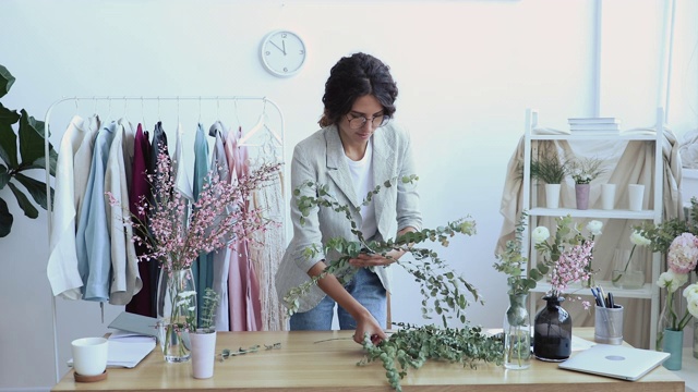 女花艺设计师在工作室进行插花创作视频素材