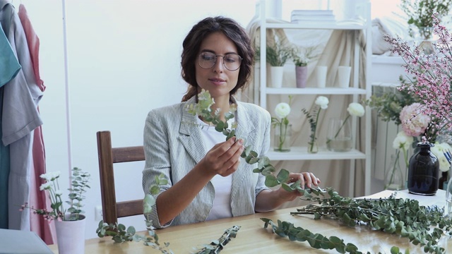 年轻设计师或花匠坐在办公桌前插花视频素材