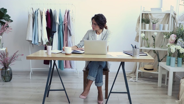 在现代服装设计工作室工作的年轻女性时装设计师视频素材