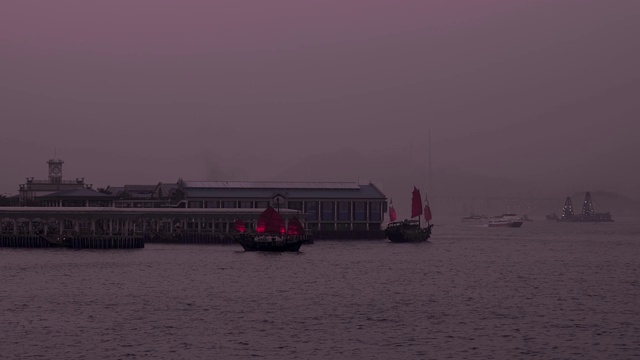 在一个紫色的黄昏，从香港中环天星码头出发的红月神号船视频素材