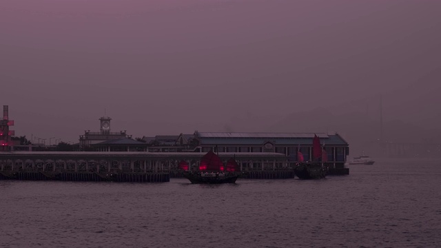 在一个紫色的黄昏，红色月神船停靠在香港中环天星码头视频素材