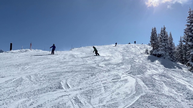 斜坡上的滑雪者和滑雪板运动员视频素材