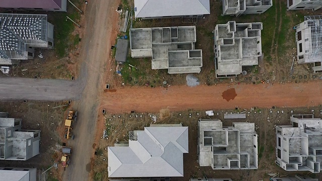 无人机飞过正在建设或未完工的建筑屋顶的视频片段，适用于住房的概念，社会条件或更繁荣的城市社区或用于与房地产相关的工作视频素材