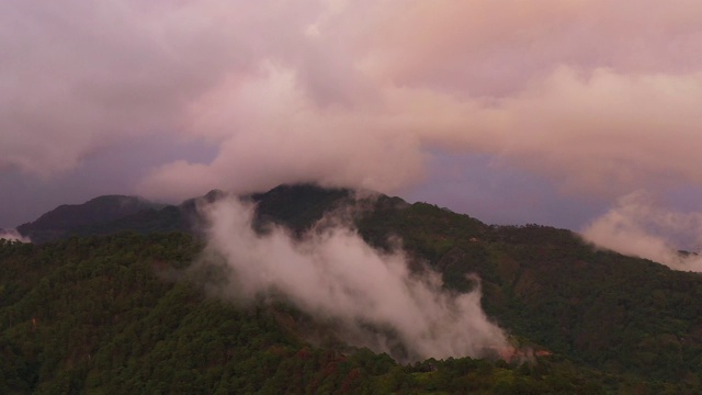 日落时分，一层层的青山和山丘笼罩在阴霾之中。美丽的日落在山上视频素材