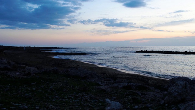 在塞浦路斯度假胜地的华丽夜晚的广角镜头。平静的地中海上的日落，海浪在海滩上翻滚。风景，自然，宁静，美丽。视频素材