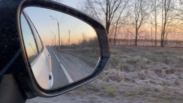 在黎明的高速公路上开车，乘客侧后视镜的特写视频素材