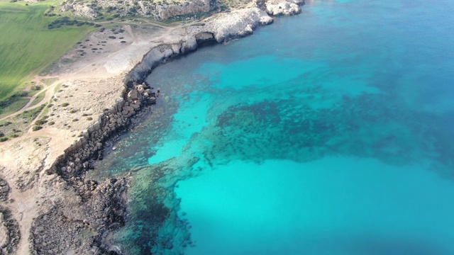 在塞浦路斯度假胜地的绿松石海环礁湖的广泛镜头。阳光明媚的夏日，地中海透明的海水和底部的石头鸟瞰图。旅游、自然、海景、美景。视频素材