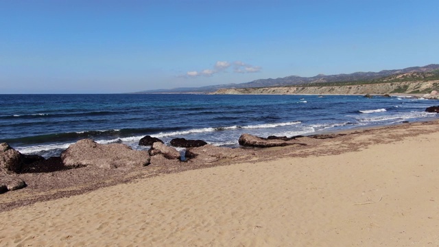 地中海的沙滩，深蓝色的海浪在阳光中溅起水花。广角镜头塞浦路斯旅游胜地在阳光明媚的一天。旅游、度假、自然、美容、海景。视频素材