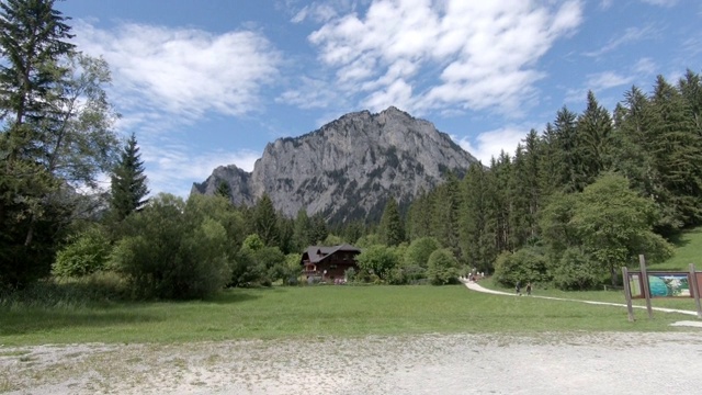 阿尔卑斯山田园诗般的山景全景。传统的房子和新鲜的绿色的山牧场在一个晴朗的日子，蓝天和云彩在夏天视频素材