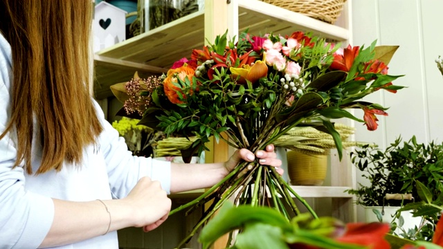 女白种人花商在花店里制作一束鲜花。4 k视频素材