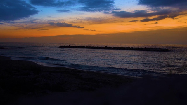 地中海上美丽的橙色日落。平静的海水拍打着海滩。晚上在塞浦路斯。自然之美，宁静之美，山水之美，海景之美。视频素材