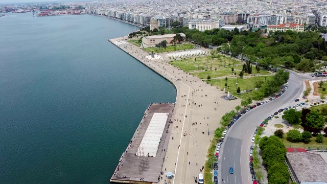 鸟瞰图城市海岸，公园与人，道路与汽车在希腊塞萨洛尼基，由无人机前进。视频下载