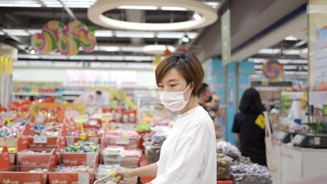 一个女人戴着一次性医用口罩在超市购物视频素材