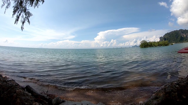 时间流逝运动海浪击中海滩的背景在海和云移动在天空快速。视频下载