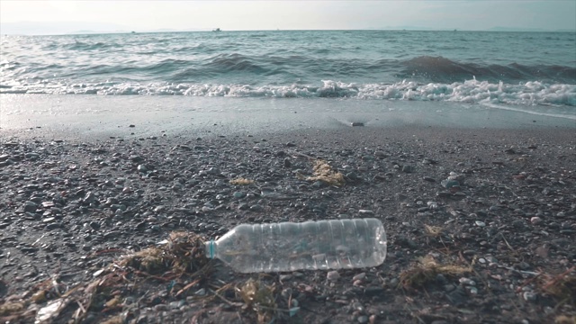 海滩上的塑料瓶。环境垃圾,浪费。全球变暖的原因。视频素材