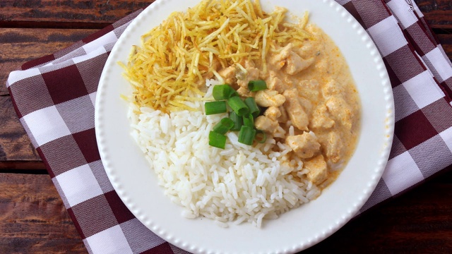 俄式炖鸡(Chicken stroganoff)源于俄罗斯美食，在巴西，这道菜由酸奶油、番茄汁、米饭和薯片组成，放在质朴的木桌上视频素材