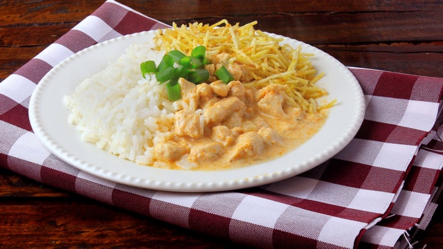 俄式炖鸡(Chicken stroganoff)源于俄罗斯美食，在巴西，这道菜由酸奶油、番茄汁、米饭和薯片组成，放在质朴的木桌上视频素材