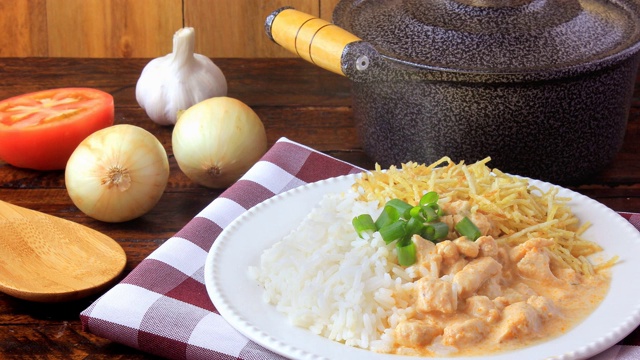 俄式炖鸡(Chicken stroganoff)源于俄罗斯美食，在巴西，这道菜由酸奶油、番茄汁、米饭和薯片组成，放在质朴的木桌上视频素材