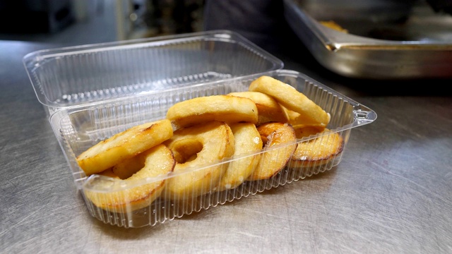 餐厅送餐服务。厨师在餐厅里准备食物，并用一次性餐具包装视频素材