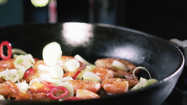 韭菜和辣椒与炸虾一起落在平底锅里，慢动作。视频素材