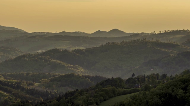 在捷克共和国的Beskydy地区，金色的夕阳在群山和山谷中缓缓升起，太阳的光线慢慢地穿透了风景和周围的自然环境视频素材