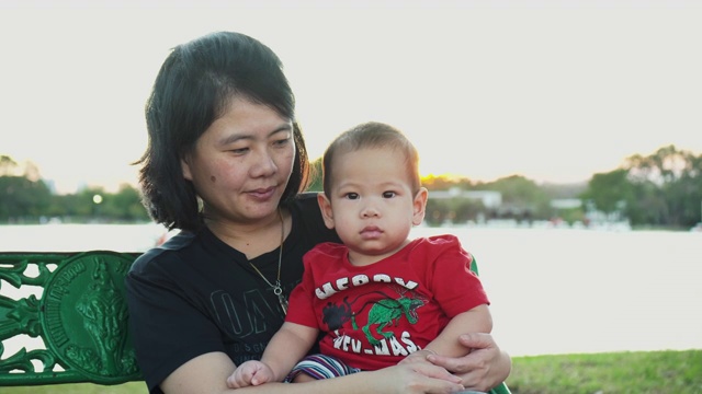 SLO MO, 4K，母亲抱着他的儿子在森林日落。视频素材