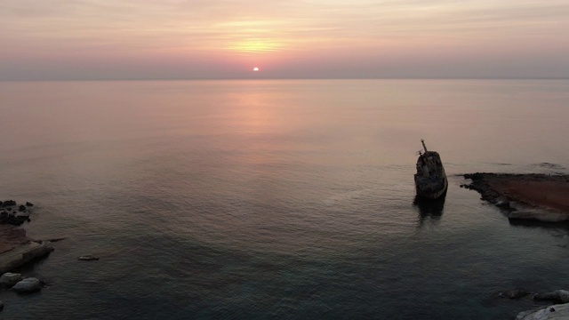 极端宽拍摄的橙色日落在塞浦路斯海岸与毁坏的旧船在水里。美丽的地中海黄昏海景。自然、美丽、景观、旅游。视频素材