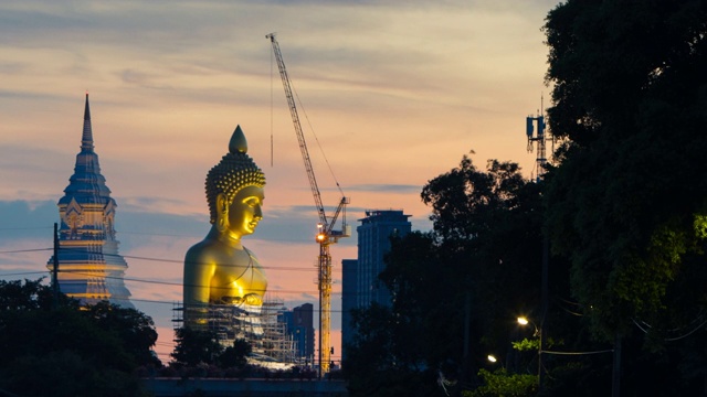 日落时分，泰国曼谷，正在修建的Wat Paknam Bhasicharoen寺的大金佛;放大运动视频素材