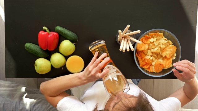 在健康饮食和不健康饮食之间选择的困难。女人选择对她有害但可口的食物。从上面的观点视频素材