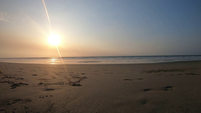 时间流逝的日落在海滩上，从表面的沙子看视频素材