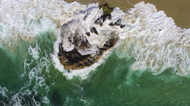 旋转的海滩岩石与海浪撞击的观点视频素材