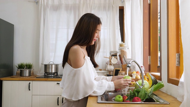 在水槽里清洗蔬菜的女人视频素材