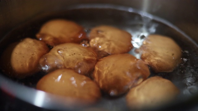 特写:在热水中煮鸡蛋，慢镜头。视频素材