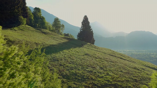 令人惊叹的鸟瞰图，一个年轻的运动员骑着电动自行车上山，美丽的景色。视频素材