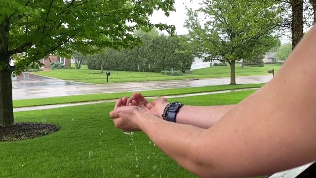 在暴风雨中，手捧着雨滴视频素材