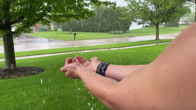 在暴雨中双手抓着雨滴]视频素材