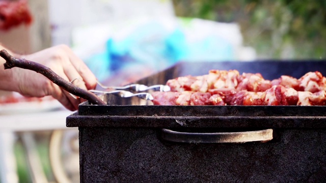 把烤肉串放在烤架上。烧烤烹饪。肉和火冒出来的烟。野餐。特写,慢动作。视频素材