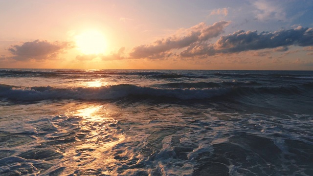 大海日出，浪花溅在沙滩上视频素材