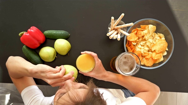 在健康饮食和不健康饮食之间选择的困难。女人选择健康的食物。从上面的观点视频素材